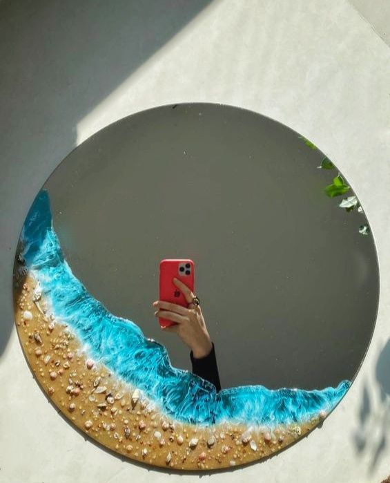 a person taking a selfie in front of a mirror with blue paint on it