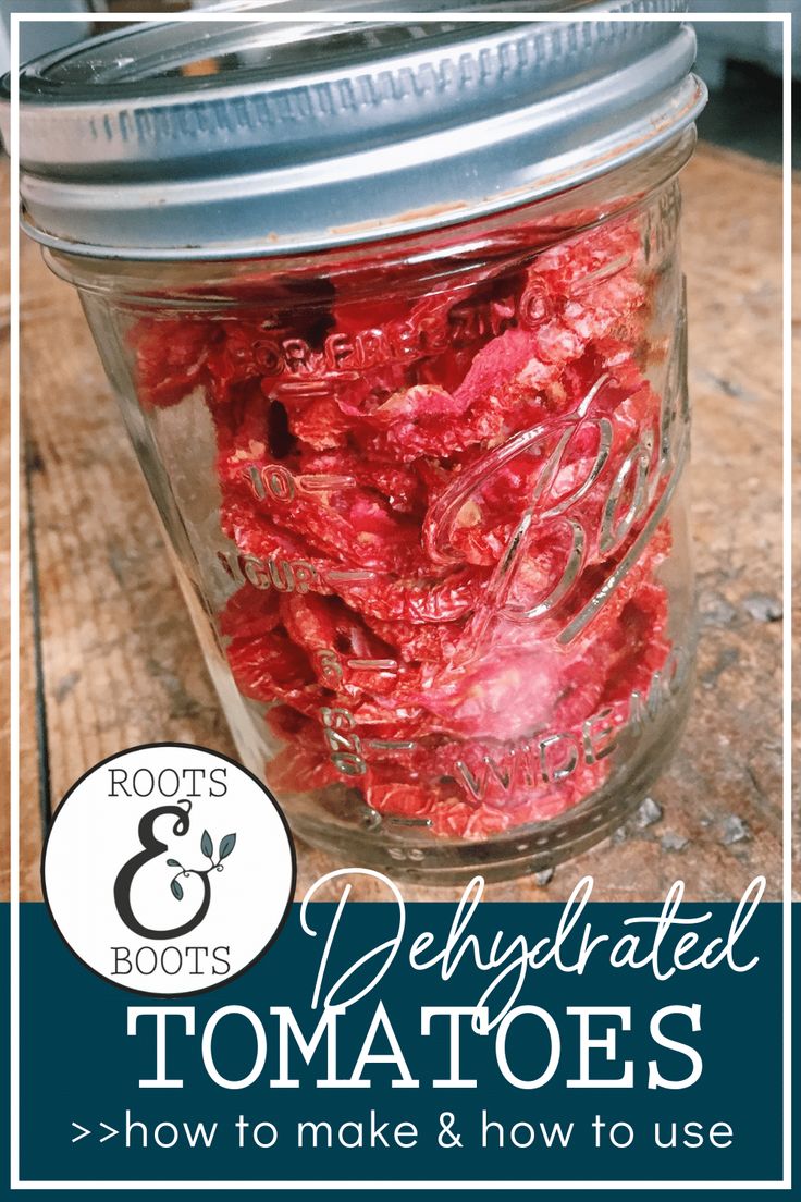 a jar filled with red tomatoes sitting on top of a wooden table