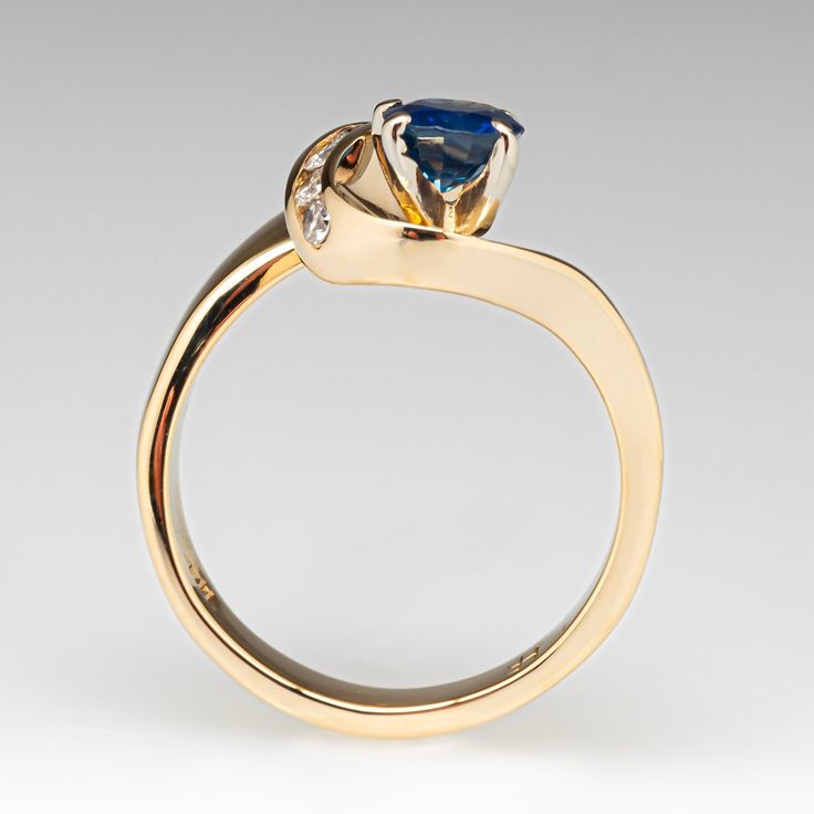 a yellow gold ring with a blue and white diamond