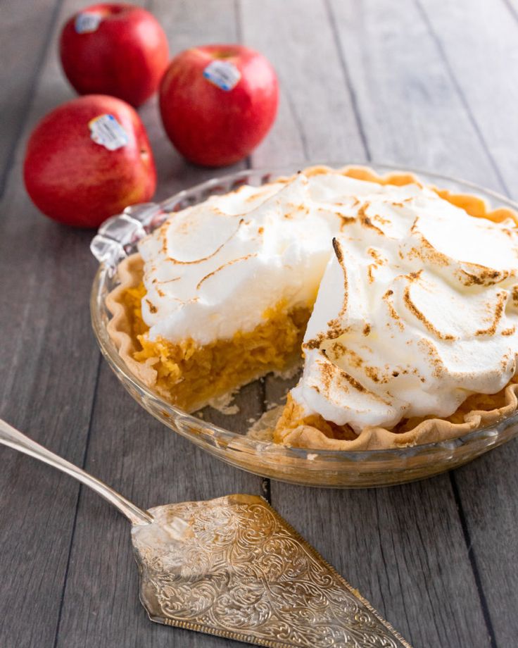 there is a pie on the table with apples in the background