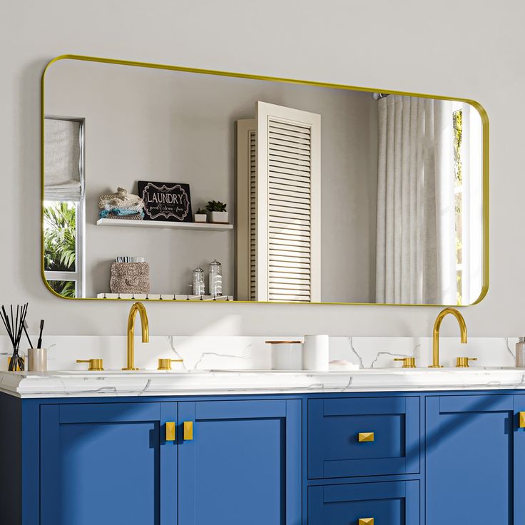 a bathroom vanity with two sinks and a large mirror above it, along with blue cabinets