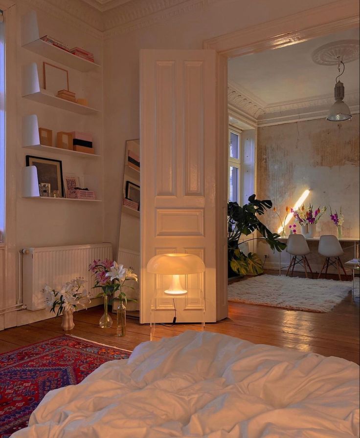 an open door leading into a bedroom with white walls and wood flooring on the other side