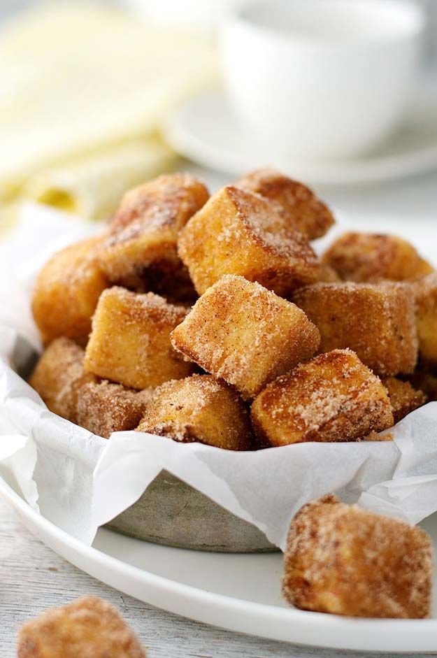 some sugared croutons are in a bowl on a table next to cups and saucers