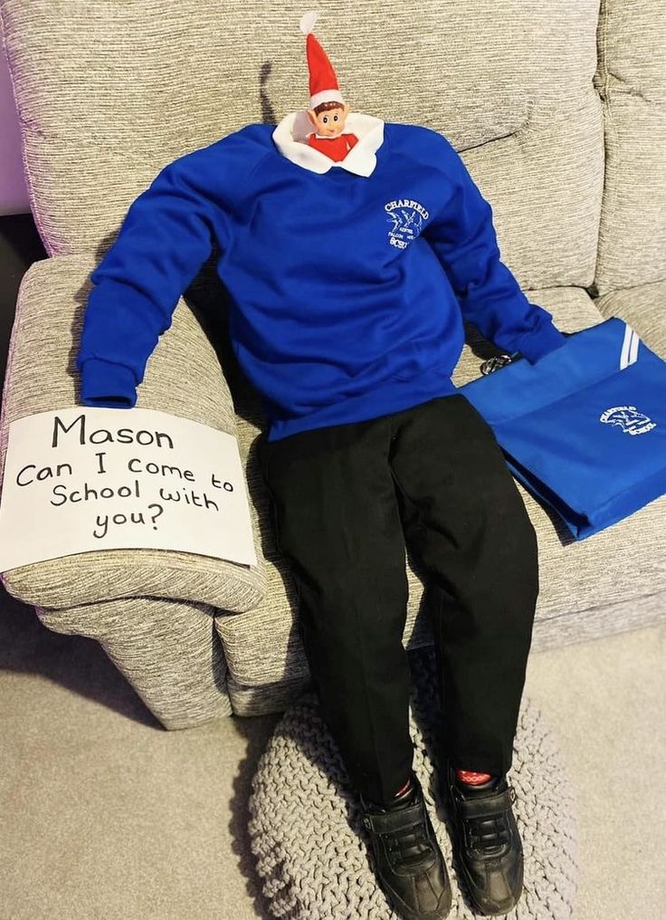 a man sitting on top of a couch wearing a blue shirt and black pants with a sign that says mason can come to school if you?