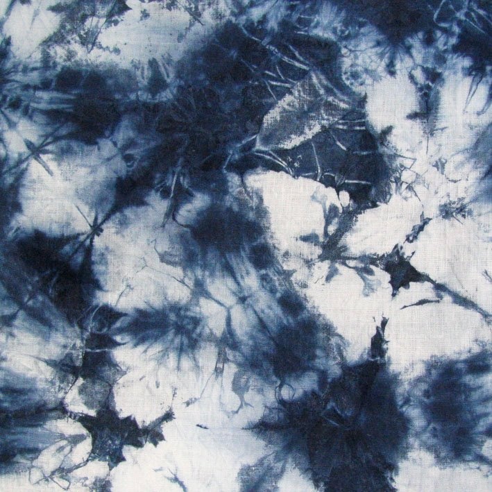 black and white abstract painting on fabric with dark blue streaks in the center, as if it were ink or paint