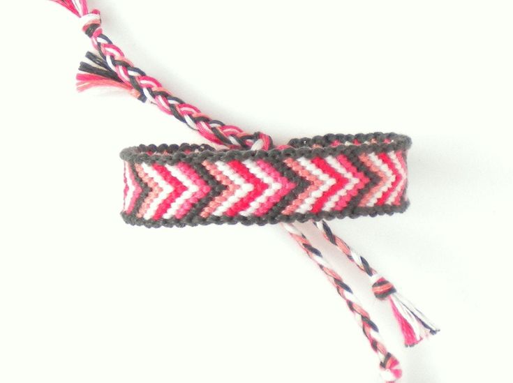 two pink and black chevroned bracelets with tassels on white background