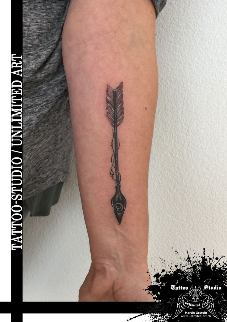 a person with a tattoo on their arm that has an arrow in the middle of it