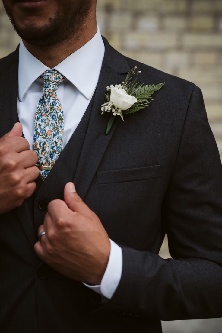 a close up of a person wearing a suit with a flower on his lapel