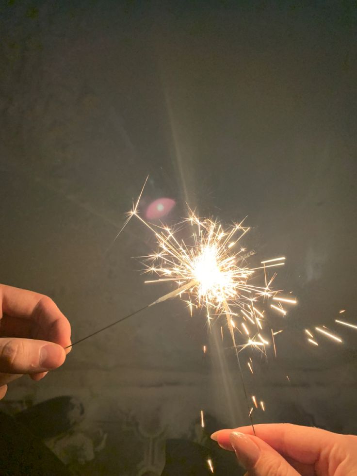 two people holding sparklers in their hands