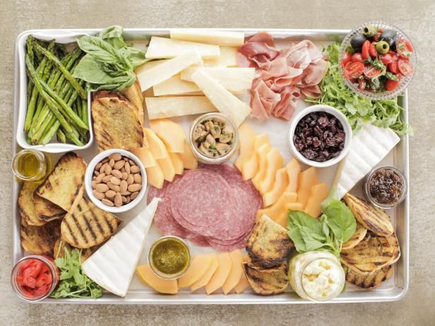 a platter filled with different types of cheese and meats