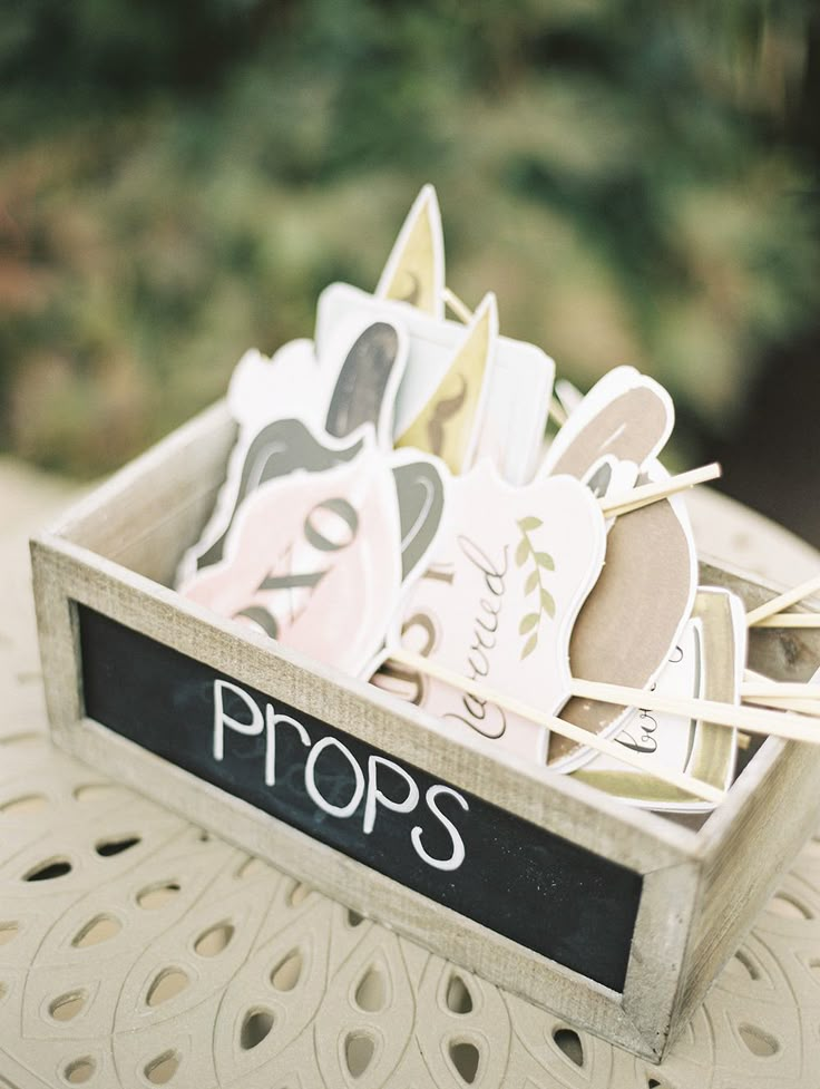 a wooden box filled with lots of cupcakes on top of a white table