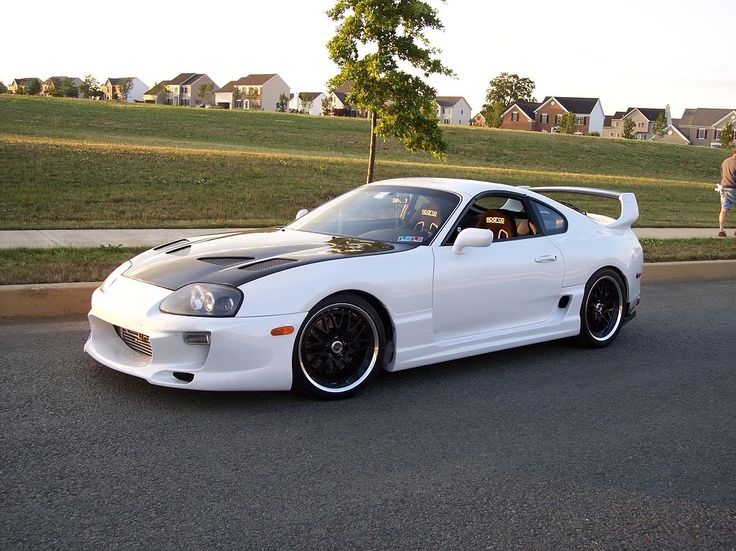 a white sports car is parked on the street