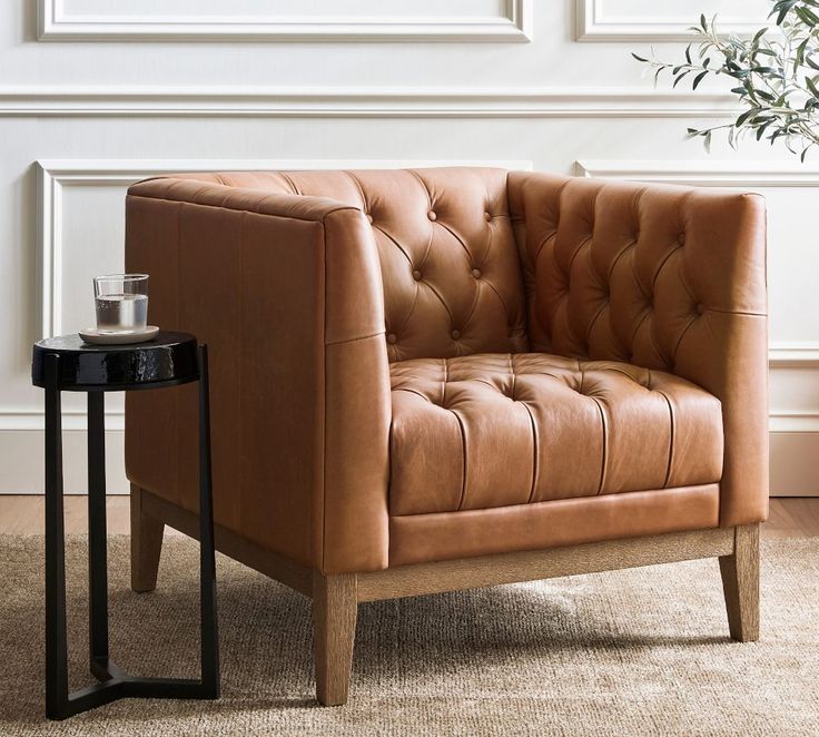 a brown leather chair next to a small table