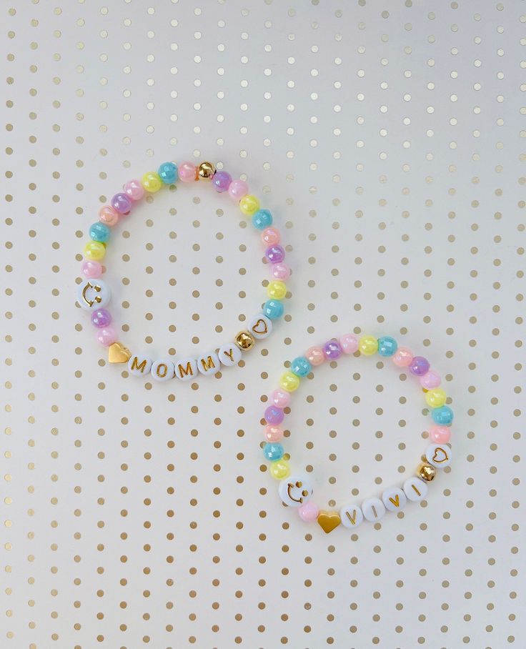 "This dainty MOMMY & DAUGHTER matching bracelet set is the cutest accessory ever! It is the best way to show off the ❤️love between you and your little girl! Each bracelet comes with a 24K heart bead and 24k gold beads AND a happy 😄 face bead to tell everyone how lucky you are to be a mom! Of course, you can have any names/words on the bracelets! 💝Add an extra charm or 2 for a low price of $1 each - https://etsy.me/36LE9om 💗We offer gift wrapping option with a nice jewelry box and make th Personalized Pink Bracelets For Mother's Day, Mother's Day Pink Name Bracelet, Matching Bracelets For Mom And Daughter, Mommy And Me Beaded Bracelets, Mommy And Me Bracelets For School, Mini Bracelet, Daughters Day, Daughter Jewelry, Rainbow Items