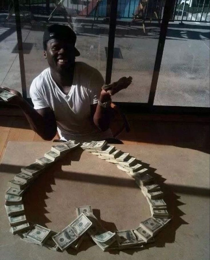 a man sitting in front of a pile of money