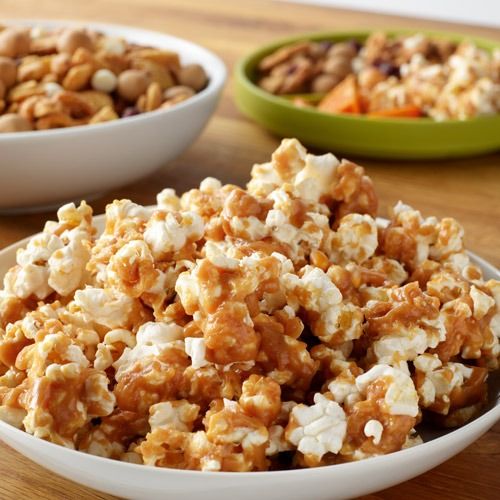 two bowls filled with popcorn sitting on top of a wooden table