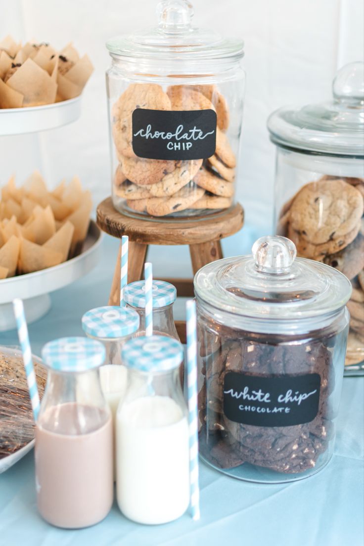 cookies and milk are on display in glass jars