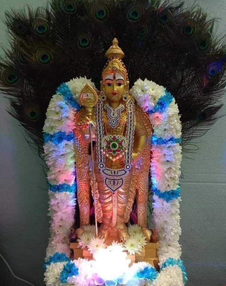 the statue is decorated with flowers and feathers