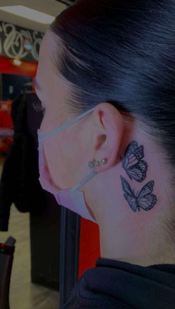 a woman with a butterfly tattoo on her ear