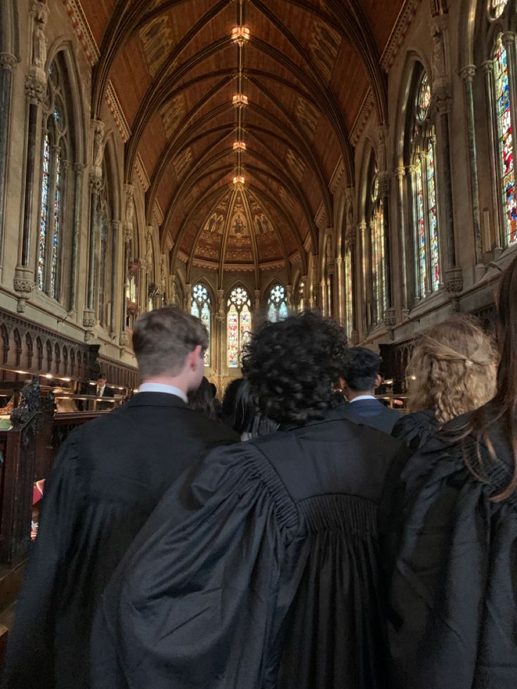 three people in robes are walking down the aisle