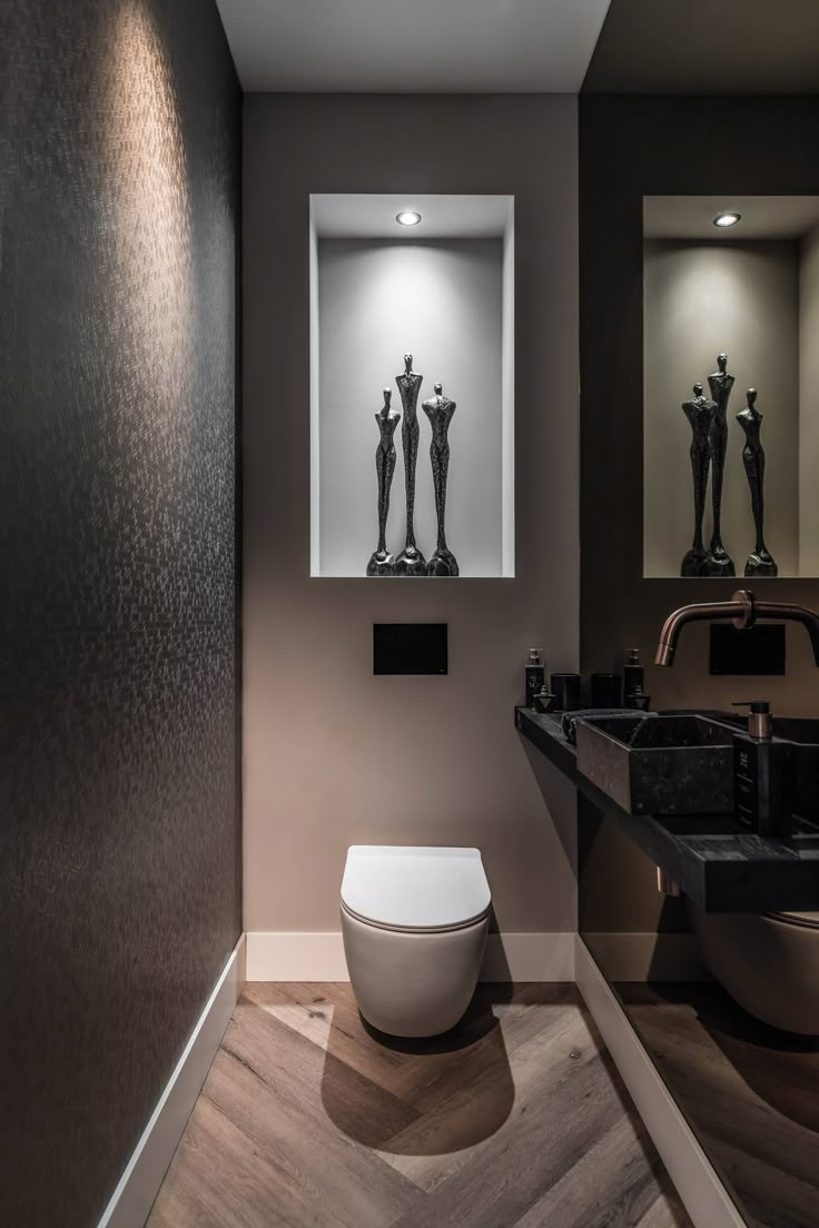 a modern bathroom with black and white artwork on the wall next to the toilet bowl