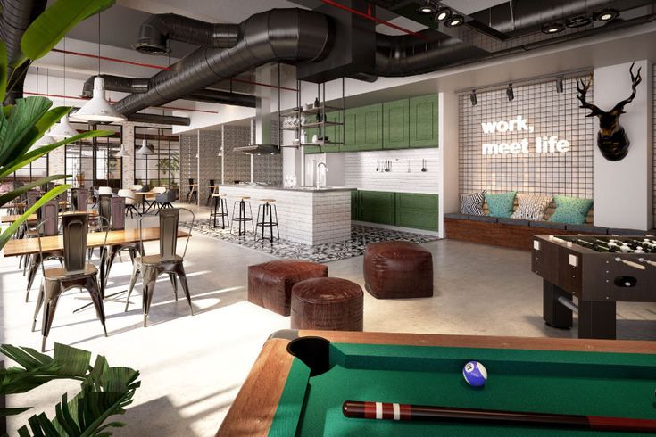 an office with pool table, bar stools and lots of green plants in it