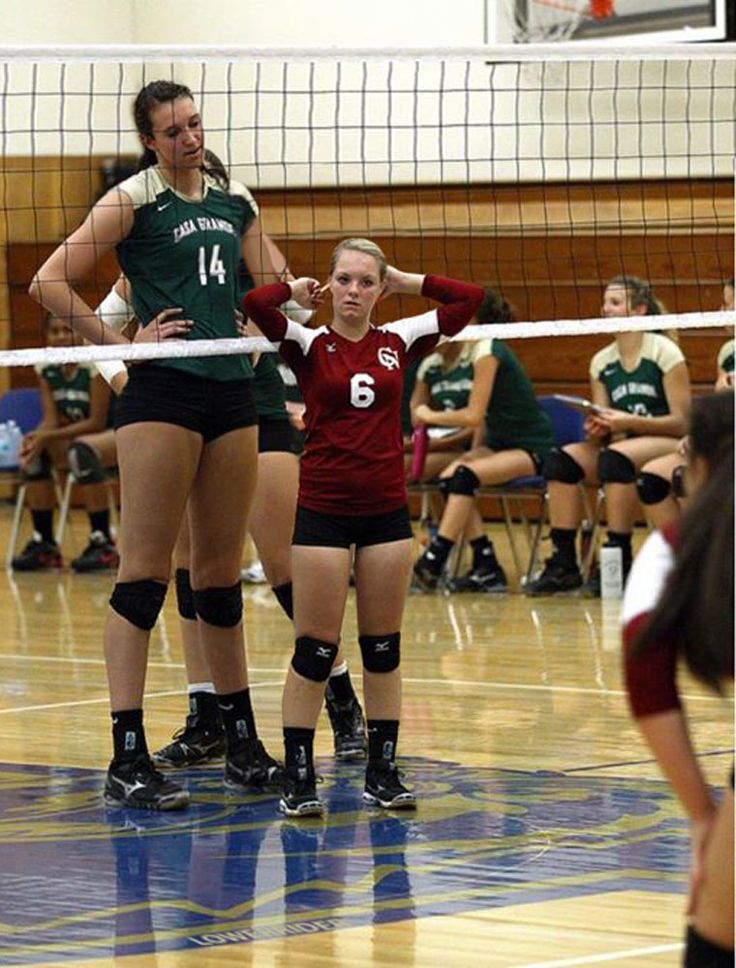 two girls are playing volleyball on the court