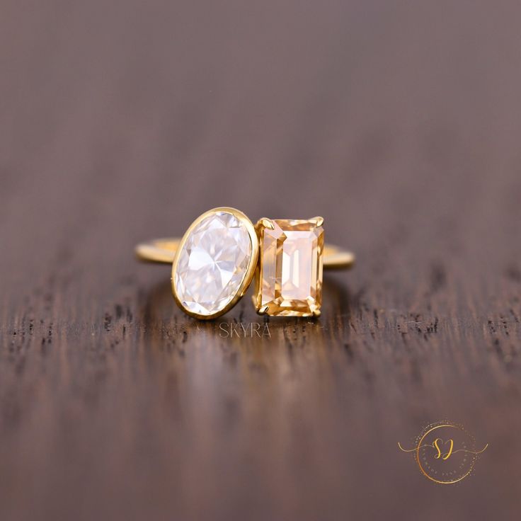 two gold rings with white stones on a wooden surface