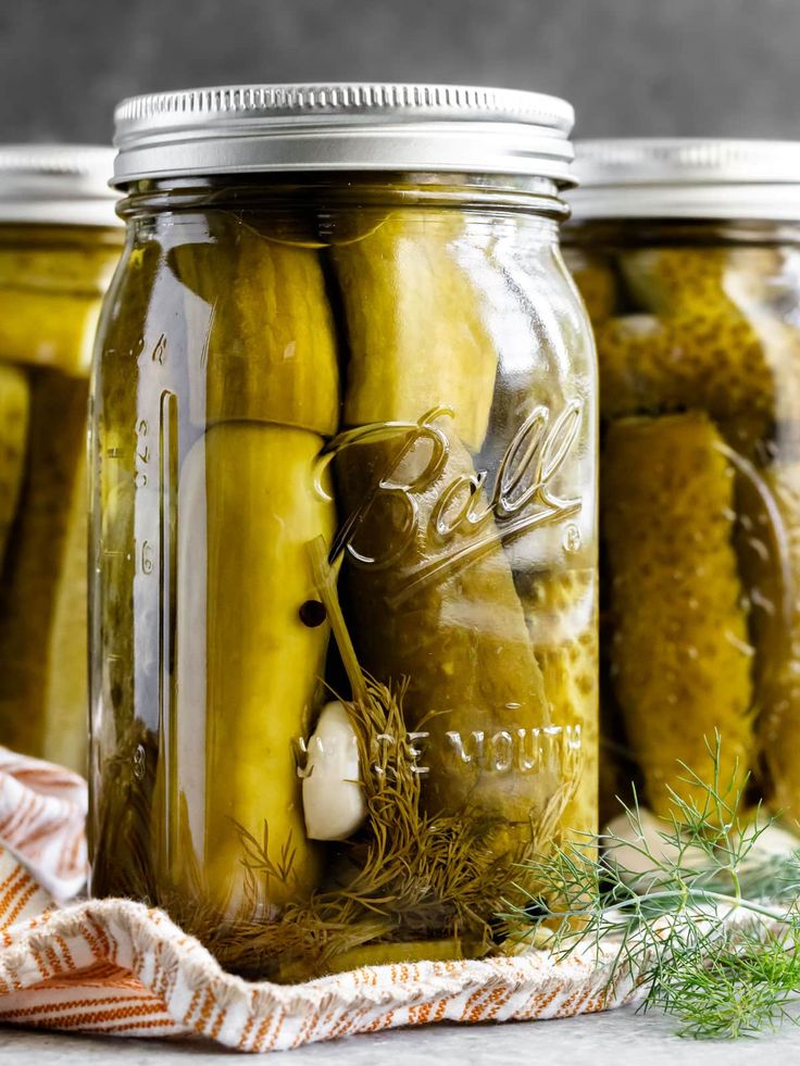 jars filled with pickles sitting on top of a table