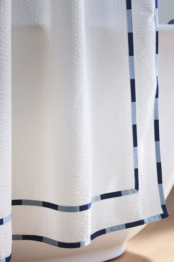 a close up of a shower curtain with blue and white stripes