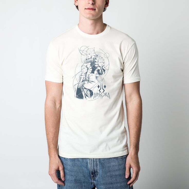 a man standing in front of a white wall wearing a t - shirt with an image of superman on it