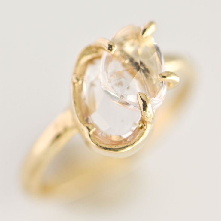 This stunning gold ring features a bold, asymmetrical design that showcases two brilliant white sapphires, totaling 1.90 carats. The sapphires are expertly set in a blend of bezel and prong settings, creating a captivating contrast between sleek minimalism and intricate detailing. 14K yellow gold 1.90tcw white sapphires Size 7.25 These white sapphires reveal a delicate pink hue when viewed under the right lighting conditions. Not your ring size? Please add a ring sizing to your cart if you need Modern 14k Gold Topaz Ring With Bezel Setting, Modern 14k Gold Bezel Set Topaz Ring, Modern Open Sapphire Ring For Wedding, Modern Diamond White Rings With Rose Cut Diamonds, Modern Crystal Ring With Bezel Setting For Promise, Modern Diamond White Rose Cut Diamond Rings, Modern Crystal Ring, Modern Oval Sapphire Ring With Prong Setting, Modern 14k Gold Diamond Ring With Rose Cut