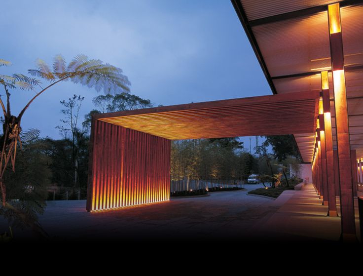 the entrance to a building lit up at night with lights shining on it's sides