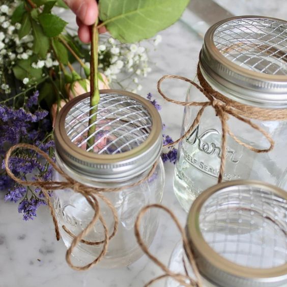 three mason jars tied with twine and some flowers