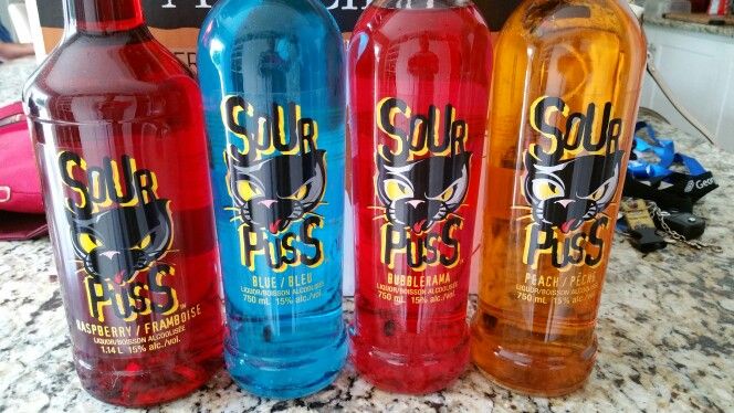 three bottles of liquid sitting on top of a counter next to a red and blue bottle