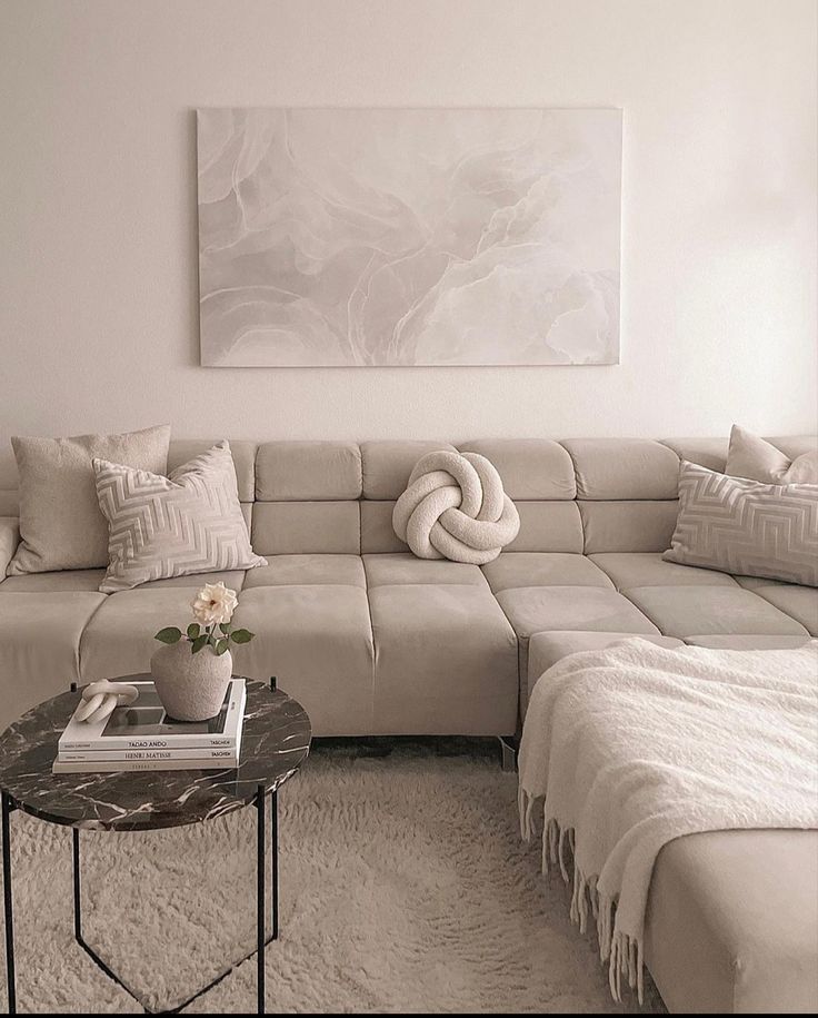 a living room with a large sectional couch and coffee table in front of the sofa