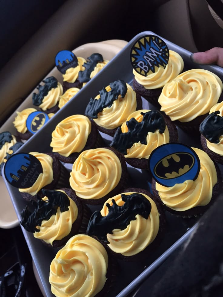 cupcakes with yellow frosting and batman decorations