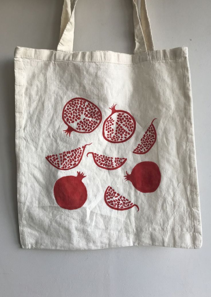 a white tote bag with pomegranates printed on the front and sides