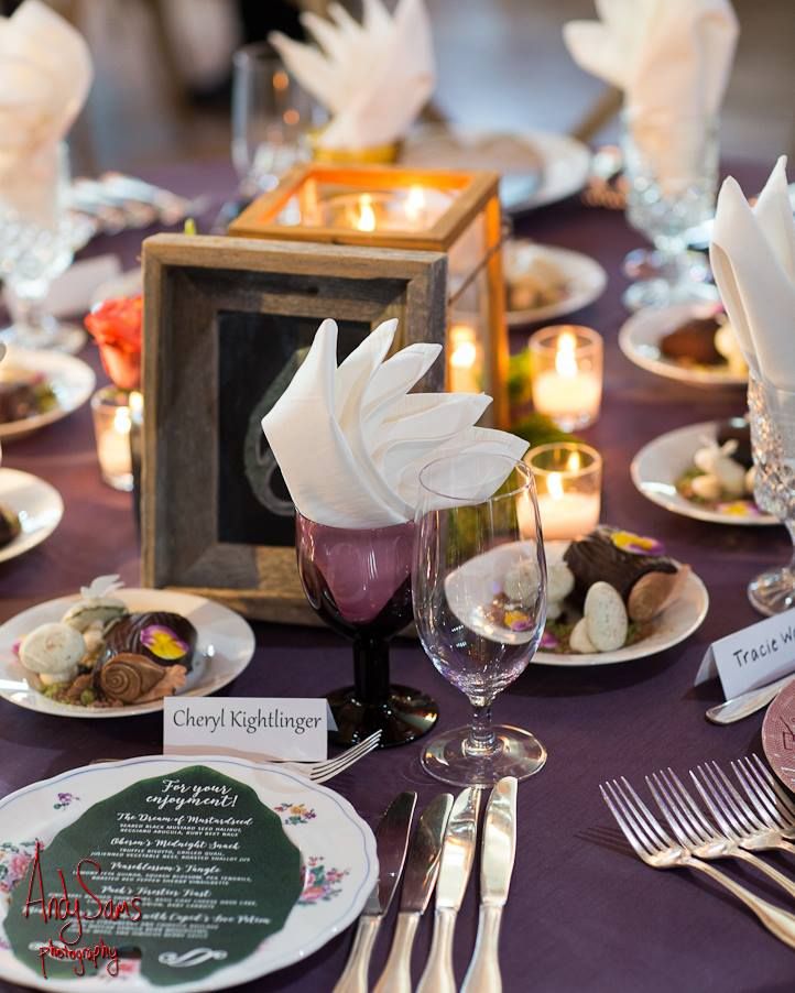 the table is set with plates, silverware and candles