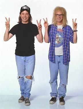 two people standing next to each other with their hands in the air and one holding up peace signs