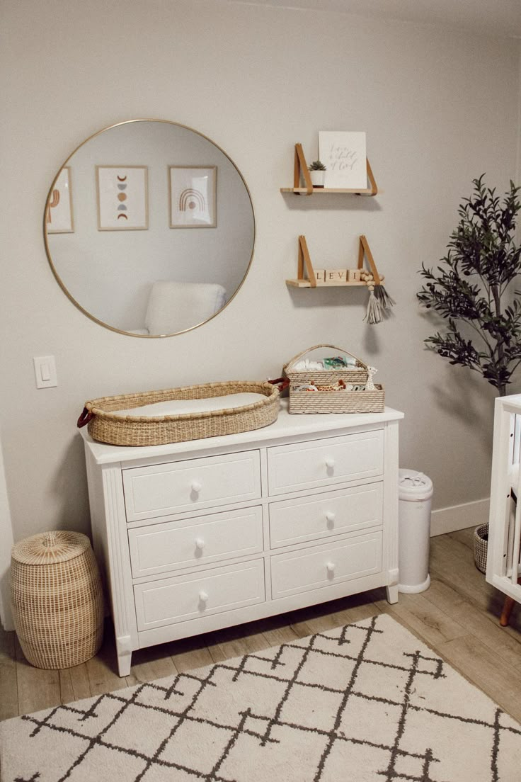 a baby's room with a crib, changing table and mirror on the wall