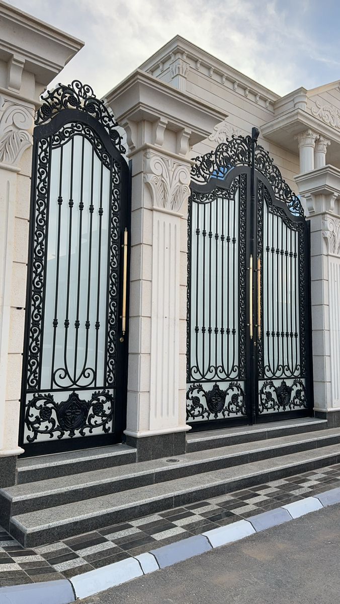 an entrance to a building with wrought iron gates and steps leading up to the front door