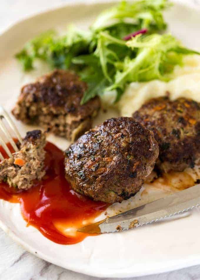 meatballs and mashed potatoes on a plate with ketchup, lettuce