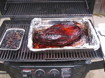 a bbq with some meat on top of it