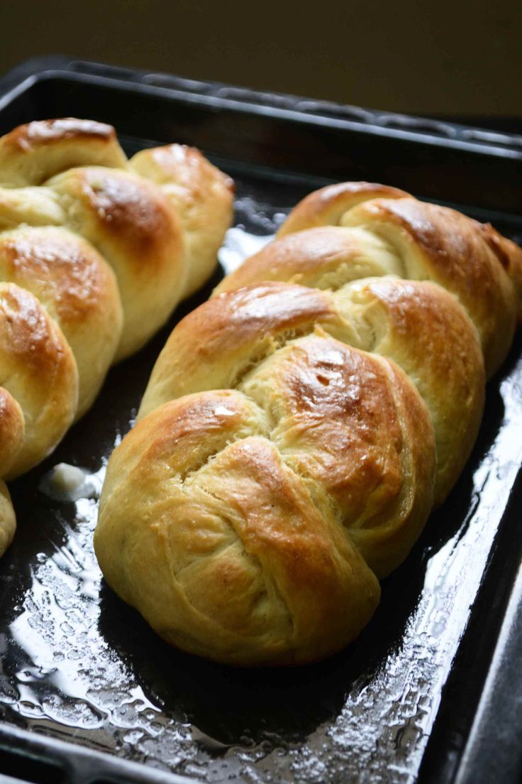 freshly baked bread rolls sitting on top of a baking sheet in an oven pan, ready to be cooked