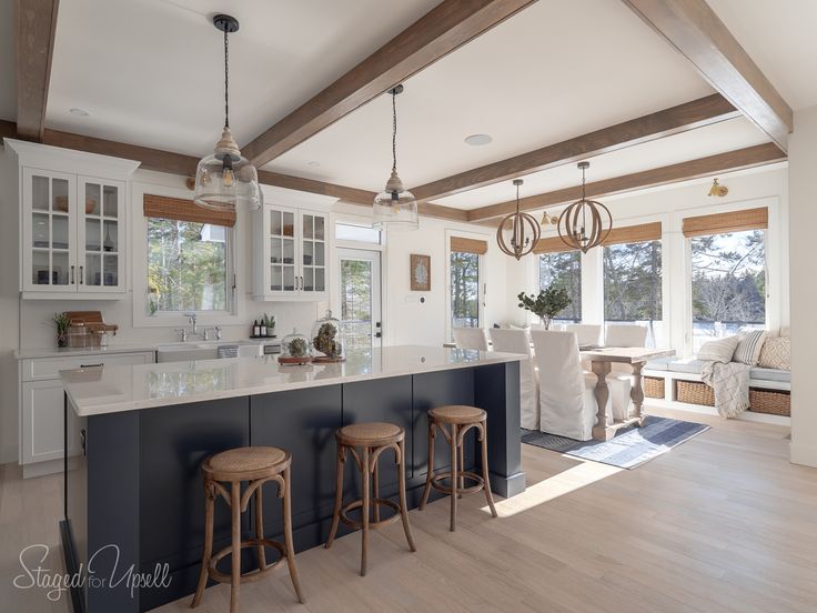 a kitchen with two stools next to an island in the middle of the room