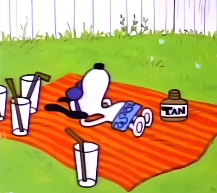 a cartoon dog laying on top of a blanket next to some bottles and cans in the grass