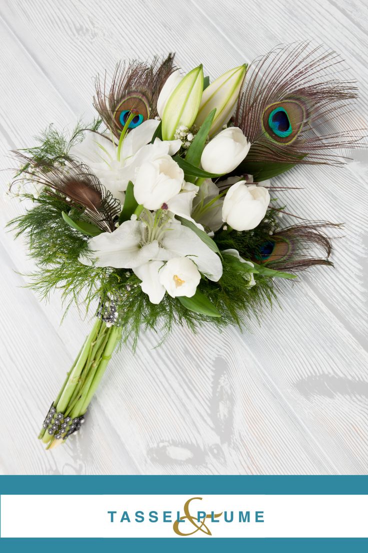 a bridal bouquet with white flowers and peacock feathers