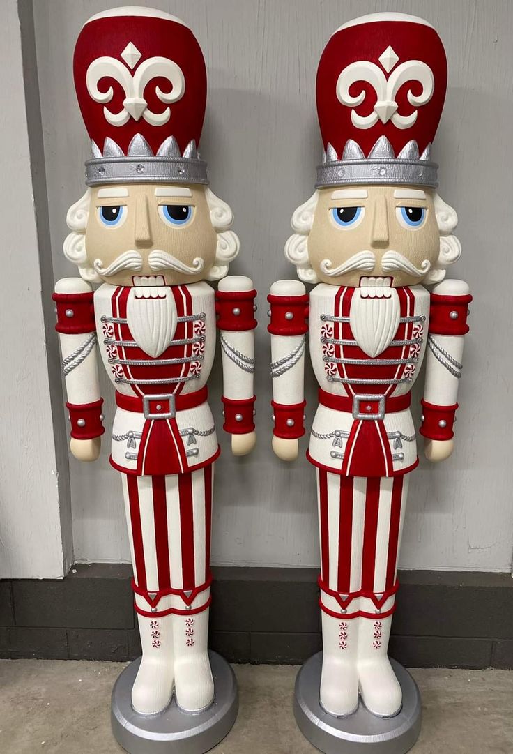 two red and white nutcrackers standing next to each other