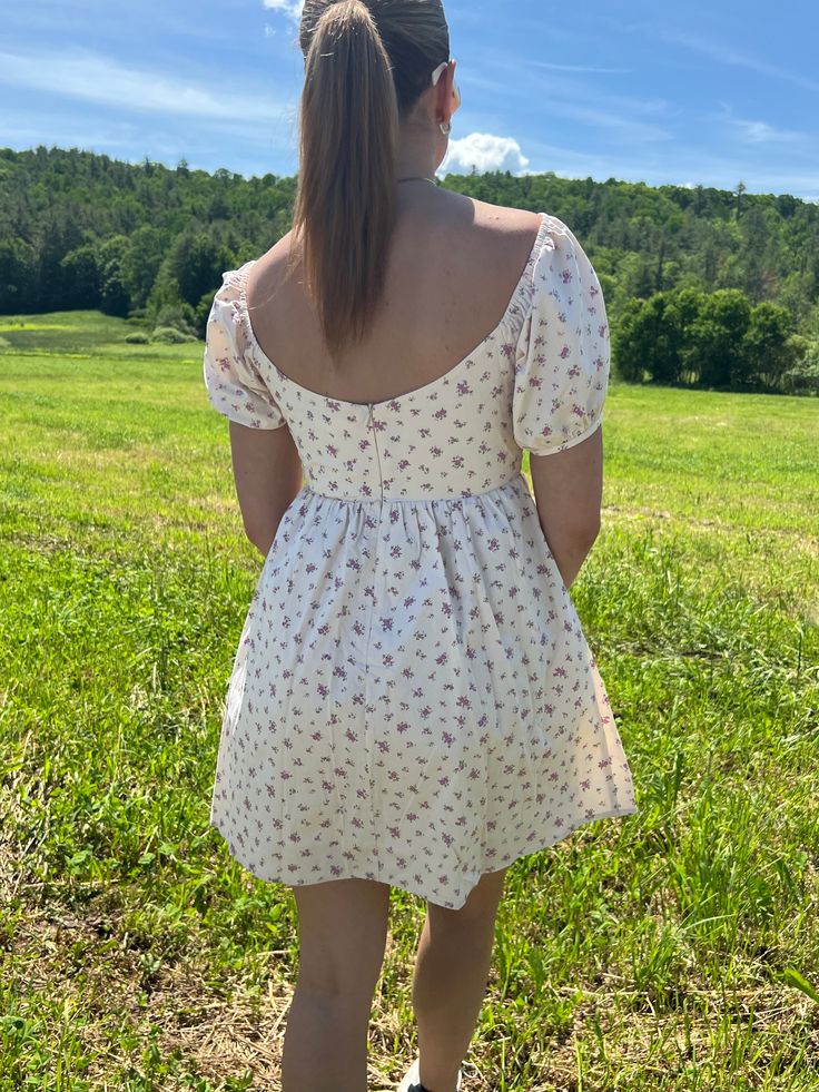 Introducing our Rosette Babydoll Dress, the perfect addition to your summer wardrobe. Made from 100% cotton, this floral mini dress exudes femininity and grace. The model is 5'3" and wearing a size small. Stay cool and stylish all summer long with this must-have dress that runs true to size. Size rec: S - 2-4 M - 4-6 L - 8-10 Square Neck Ditsy Floral Dress For Day Out, Feminine Mini Floral Dress With Ditsy Print, Feminine Ditsy Floral Mini Dress, Cotton Mini Dress For Picnic, Feminine Cotton Mini Dress With Ditsy Floral Print, Summer Floral Dress With Square Neck For Day Out, Summer Floral Dress With Ditsy Print And Square Neck, Cottagecore Mini Dress For Garden Party, Summer Ditsy Floral Print Dress With Square Neck